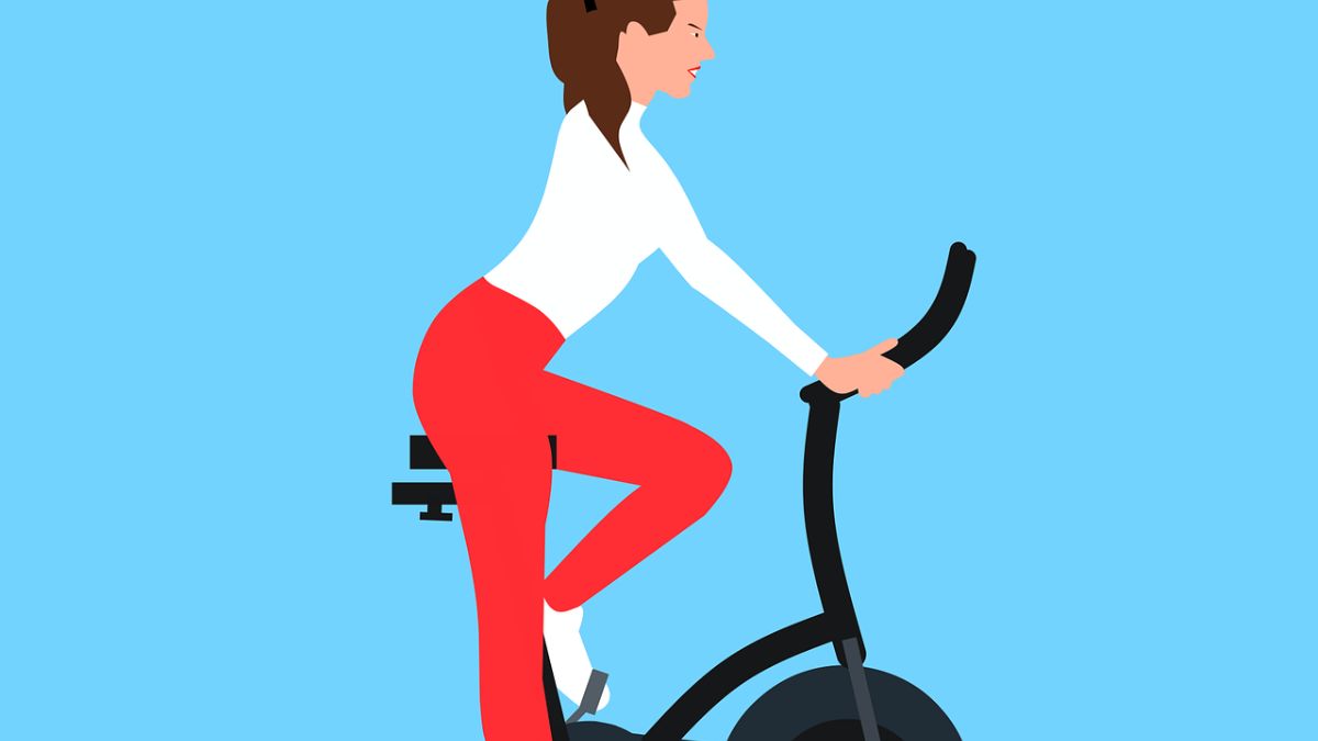 mulher fazendo treino em bicicleta ergométrica.