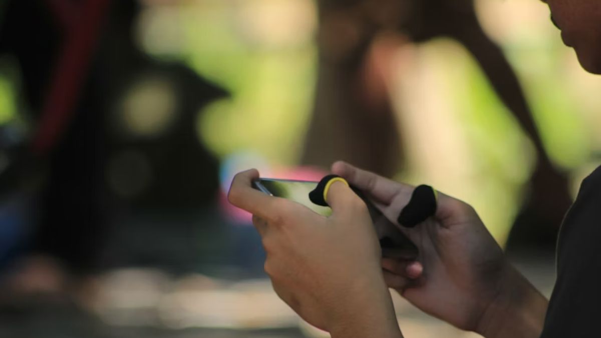 garoto jogando jogos para celular.