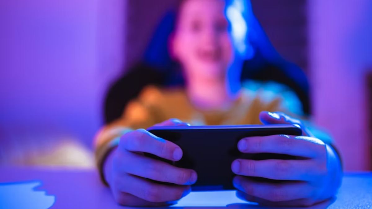 Menino jogando em aparelho mobile.