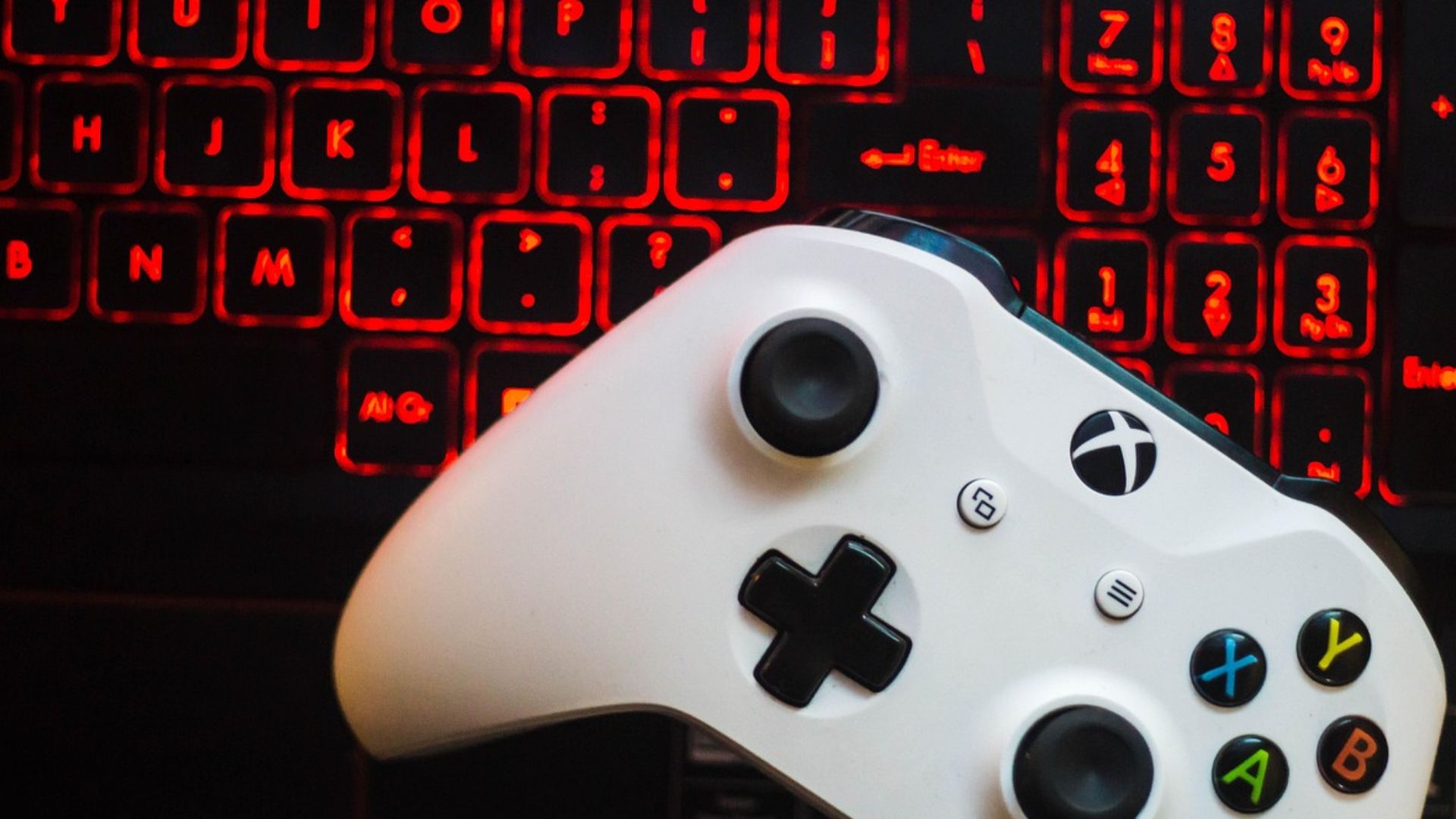 Controle de VideoGame sobre teclado aceso controlam as mesmas telas.