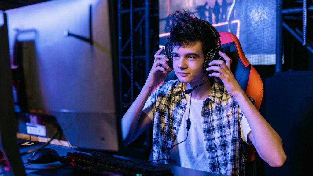 Jovem em um ambiente moderno de games, focado e preparado para uma partida.