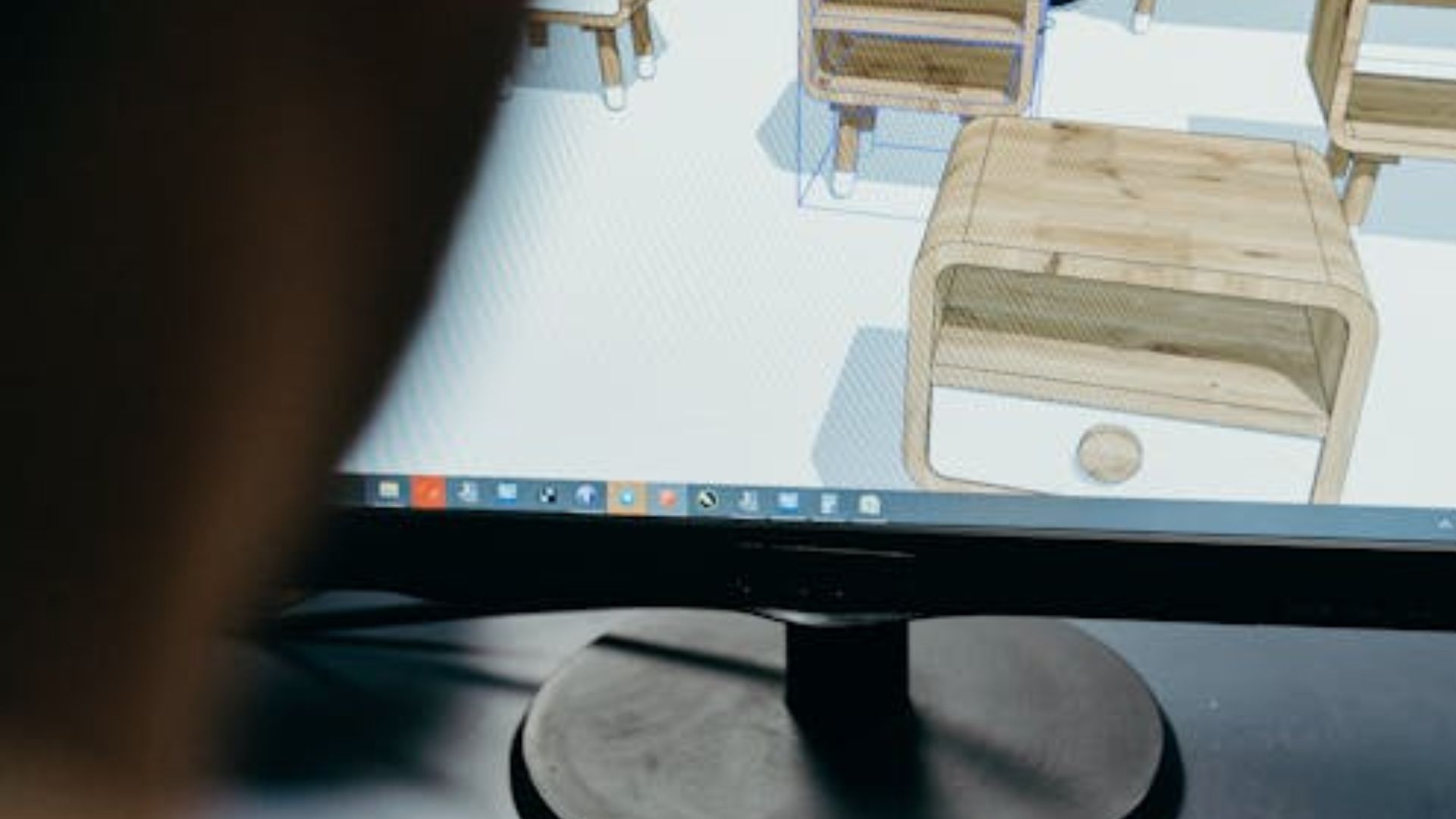 Tela de monitor exibindo o processo de design 3D de um criado-mudo de madeira com acabamento moderno.